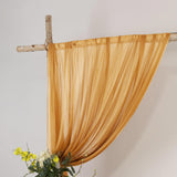 Golden sheer drape on rustic wooden frame with floral arrangement