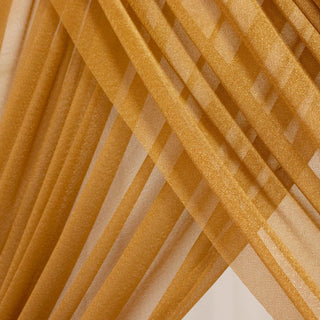 Golden sheer fabric with layered diagonal folds and soft light reflections