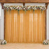 Gold wedding backdrop with floral garland, sheer curtain, and wooden frame