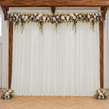 Rustic wedding arch with white drapes and blush floral garland
