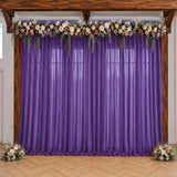 Purple wedding backdrop with floral garland and sheer curtains
