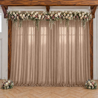 Rustic wedding backdrop with floral garland, beige drapes, and wooden arch