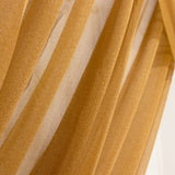 Golden sheer fabric draped in soft pleats with striped texture