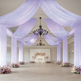Elegant event space with draped fabric and floral arrangements for weddings.