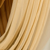 Soft, flowing fabric drapes in warm beige and gold tones.