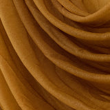Brown sheer fabric draped in soft folds, showcasing its delicate texture. #whtbkgd