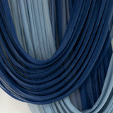 Blue sheer fabric drapes in flowing layers, creating an elegant texture.