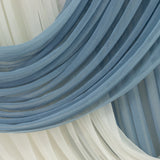 Soft blue and white draped fabric in flowing layers.