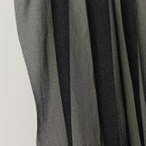 Sheer black fabric displaying a textured pattern.