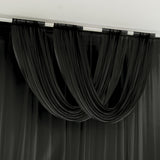 Black draped curtains in a modern interior setting.