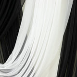 Sheer black and white fabric drapes, showcasing elegant texture and flow.