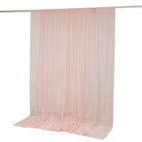 Pink sheer curtain panel hanging from a rod with soft draped fabric