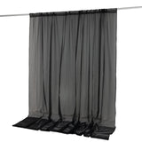 Black sheer curtain panel hanging on rod with translucent fabric