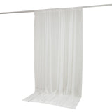 White sheer curtain panel hanging on a rod with floor-length drape