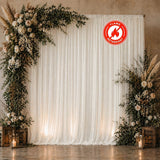 Floral wedding backdrop with white drapes and fire retardant label