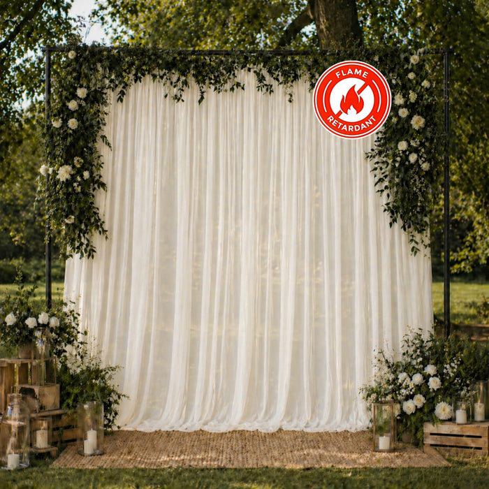 Elegant outdoor wedding backdrop with floral arch and flame-retardant drapery