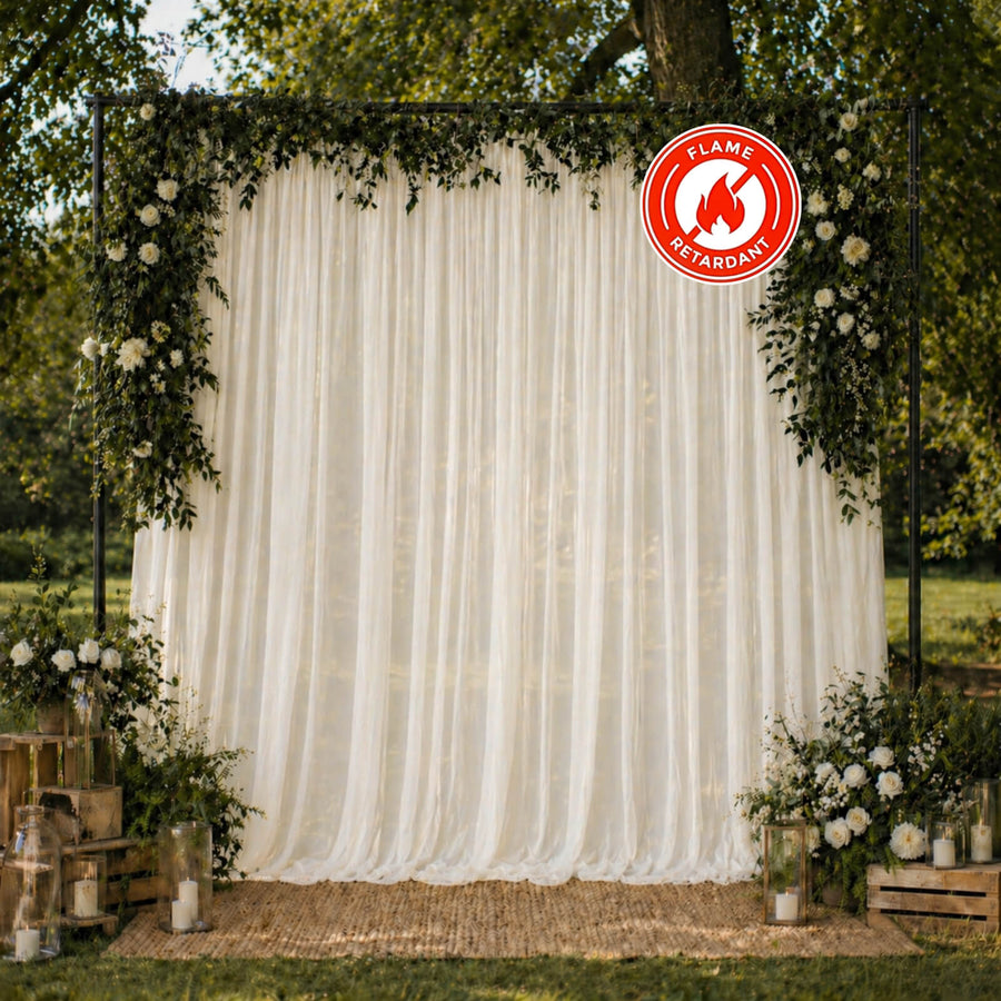Elegant outdoor wedding backdrop with floral arch and flame-retardant drapery