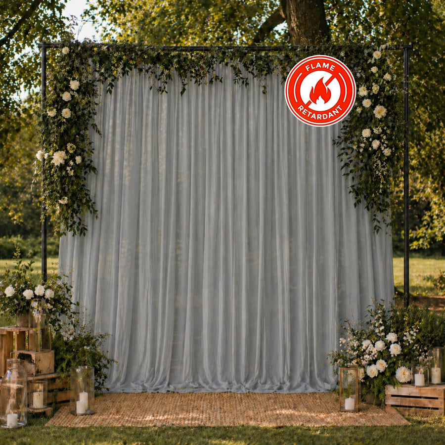 Elegant outdoor wedding backdrop with florals and flame retardant drape