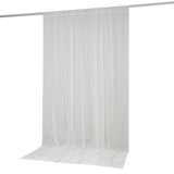 White sheer curtain panel hanging from rod with floor-length drape