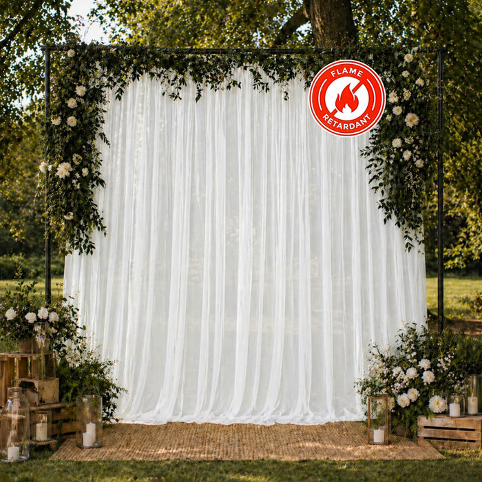 Outdoor floral wedding backdrop with white drapes and flame-retardant sign