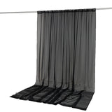 Black sheer curtain panel hanging on a rod, elegant floor-length drape