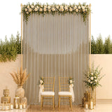 Elegant gold wedding backdrop with white roses, sheer drapes, and chairs