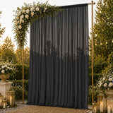 Elegant outdoor wedding backdrop with black drape, roses, lanterns, and gold frame