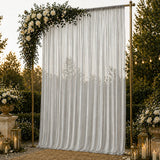 Elegant wedding backdrop with white drapes, gold frame, roses, and lanterns