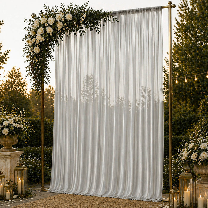 Elegant wedding backdrop with white drapes, gold frame, roses, and lanterns