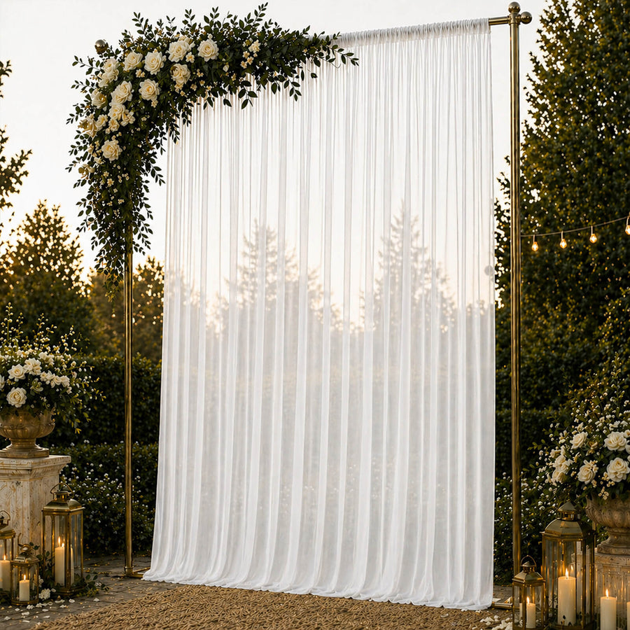 Elegant wedding backdrop with white drapes, roses, and gold lanterns