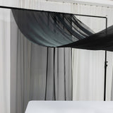 Black sheer fabric draped on a frame against white curtains.