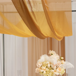 Elegant floral centerpiece with soft fabric drapery above.