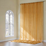 Sheer golden curtain draping elegantly in a sunlit room.