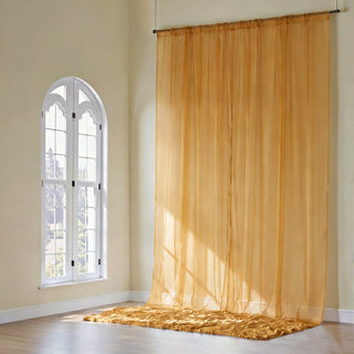 Sheer golden curtain draping elegantly in a sunlit room.