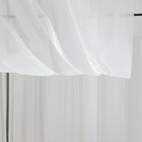 Sheer white fabric draping elegantly in a studio setting.