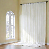Sheer white curtains gently flowing in a bright, airy room.