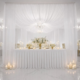 Elegant wedding reception decor with white flowers and candles.
