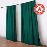 Green flame retardant curtains hanging on a black rod indoors