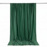 Green satin curtain hanging on a rod with elegant draped folds