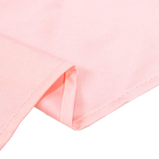 Close-up of a light pink ribbed knit fabric with folded hem details