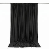 Black satin curtain draped on rod, elegant backdrop on white background