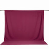 Burgundy fabric backdrop draped over a metal rod on white background