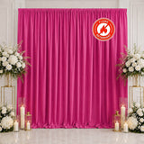Pink flame-retardant curtain backdrop with white floral arrangements and candles