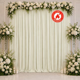 Elegant white floral wedding backdrop with cream drapes and candles, flame retardant