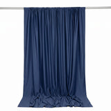Navy blue curtain draped on rod, elegant fabric backdrop with flowing folds