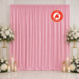 Pink satin event backdrop with floral arrangements and candles, flame retardant