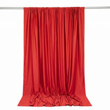 Red satin curtain hanging on a rod with flowing draped fabric