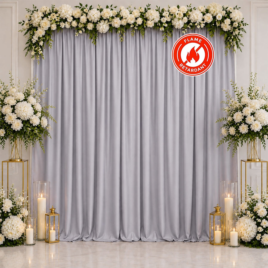 Elegant white floral wedding backdrop with gray drape and candles, flame retardant