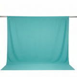 Turquoise fabric backdrop hanging on a studio backdrop stand