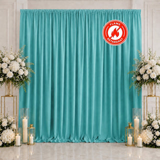 Turquoise curtain backdrop with white floral arrangements and candles